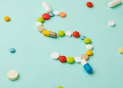 Unpacking Drug Value forum banner photo of prescription drugs arranged in a dollar sign