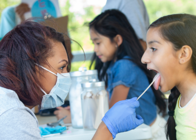 Nurse swabbing a child's mouth