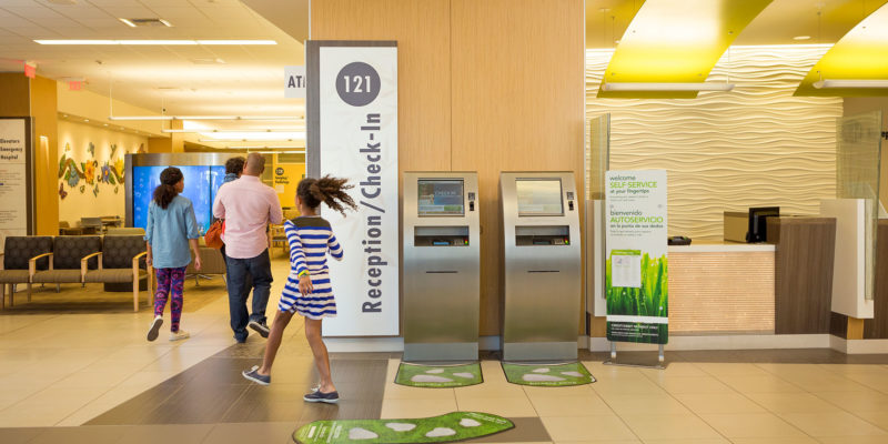 girl skipping past reception kiosk