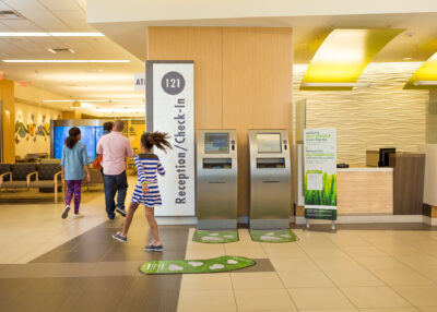 girl skipping past reception kiosk