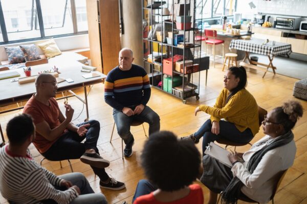 Young Man Talking In Group Therapy At A Coworking