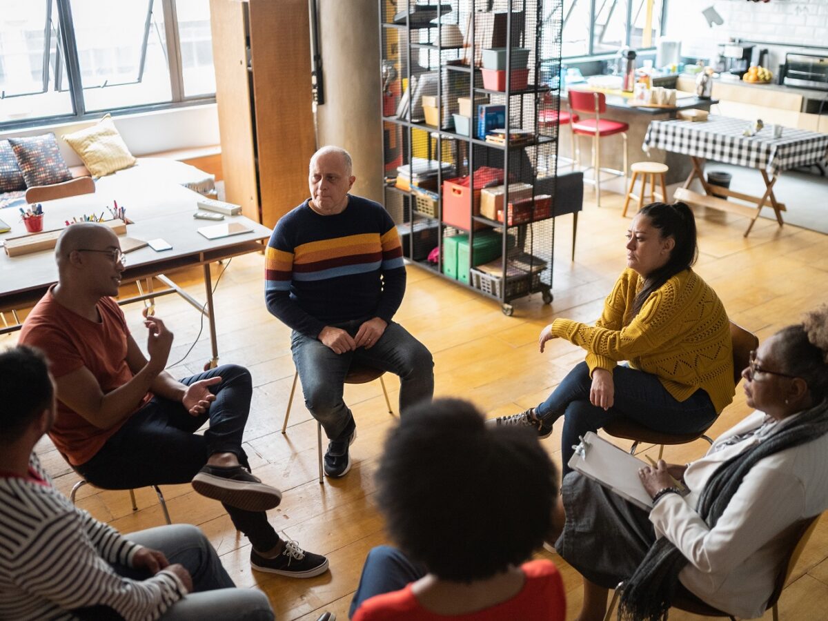 Young Man Talking In Group Therapy At A Coworking