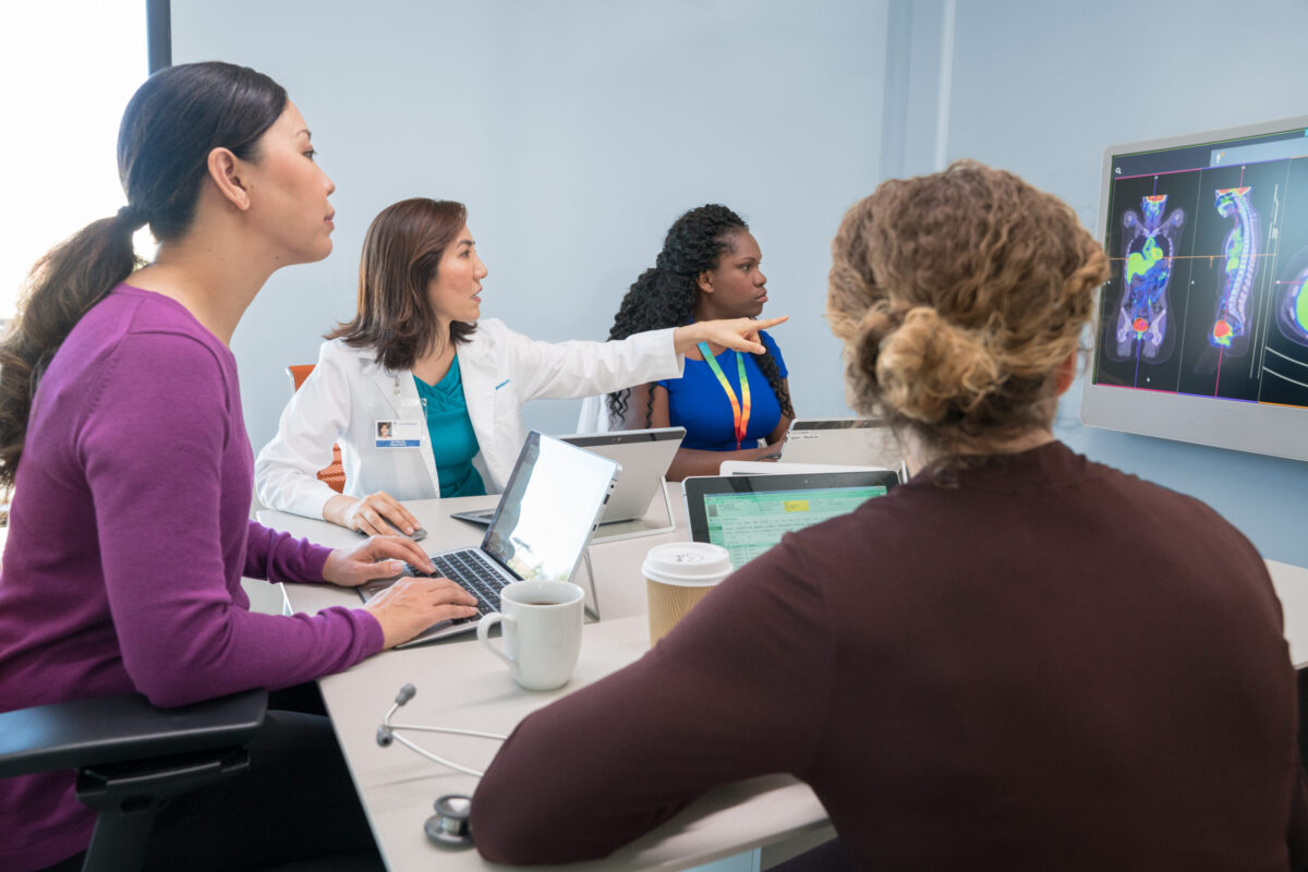 Doctors in conference room on video call