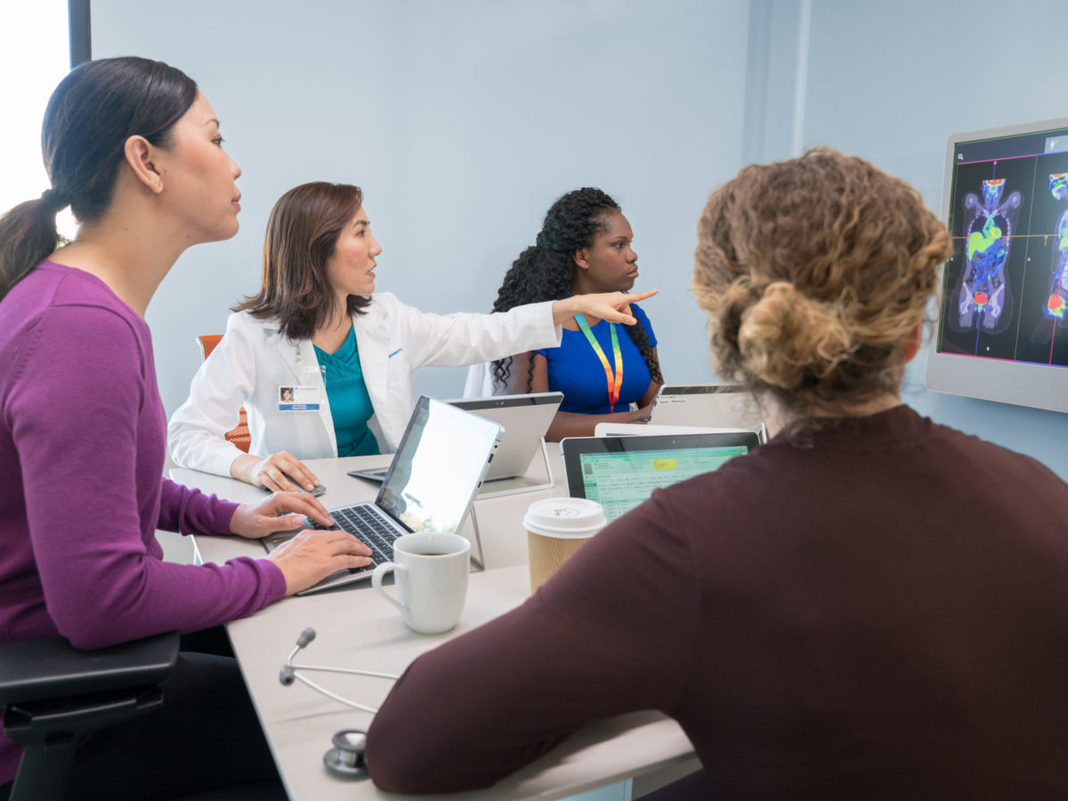 Doctors In Conference Room On Video Call