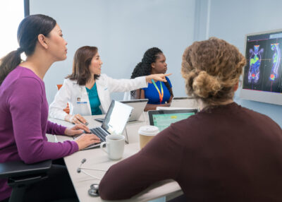 Doctors in conference room on video call
