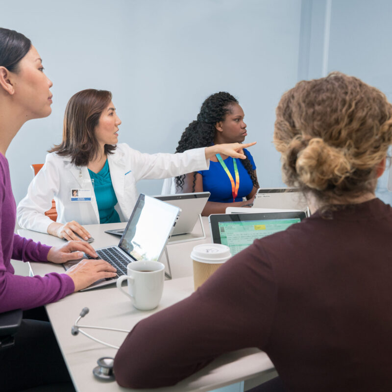 Doctors in conference room on video call