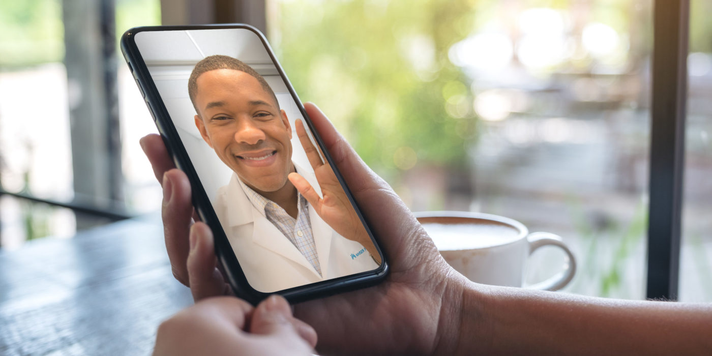 Woman's Hands Holding Black Mobile Phone With Doctor On Screen