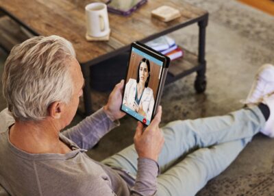 Man on telehealth visit with doctor using tablet