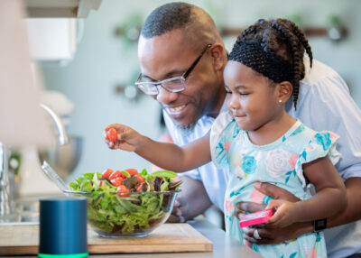 Toddler girl preparing food with father