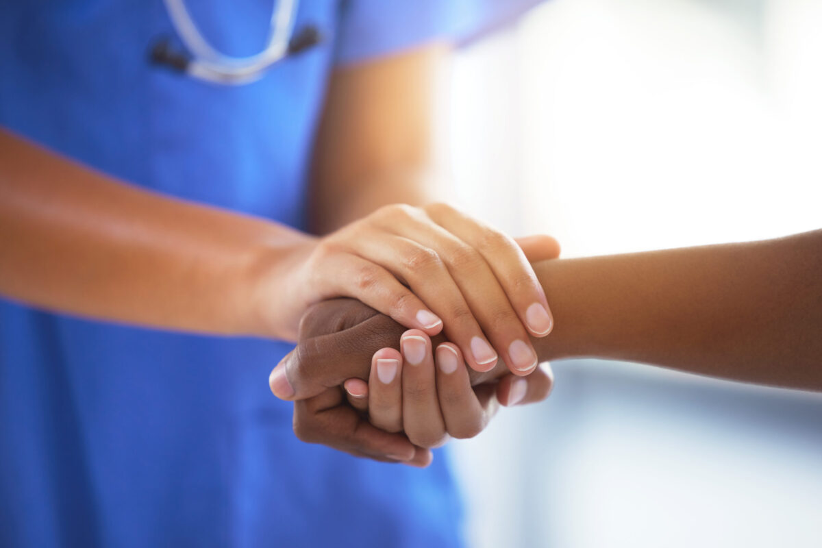 Shot of an unrecognizable doctor holding hands with her patient during a consultation