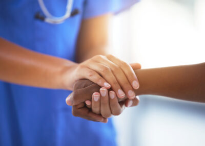 Shot of an unrecognizable doctor holding hands with her patient during a consultation