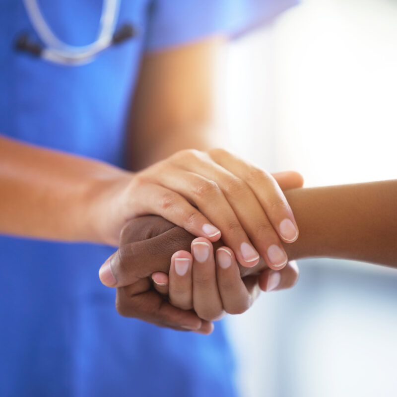Shot of an unrecognizable doctor holding hands with her patient during a consultation