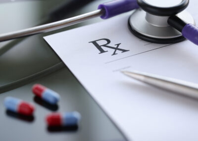 Ballpoint pen lying on medical prescription near phonendoscope in doctors office. Illegal prescription of drugs concept