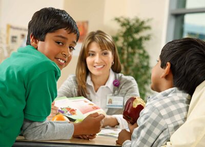 Kaiser employee interacting with two children.