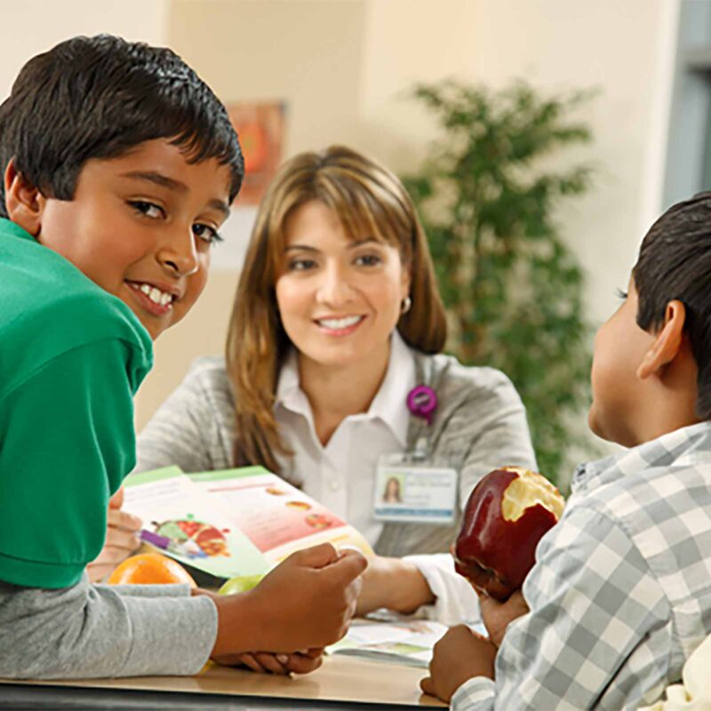 Kaiser employee interacting with two children.