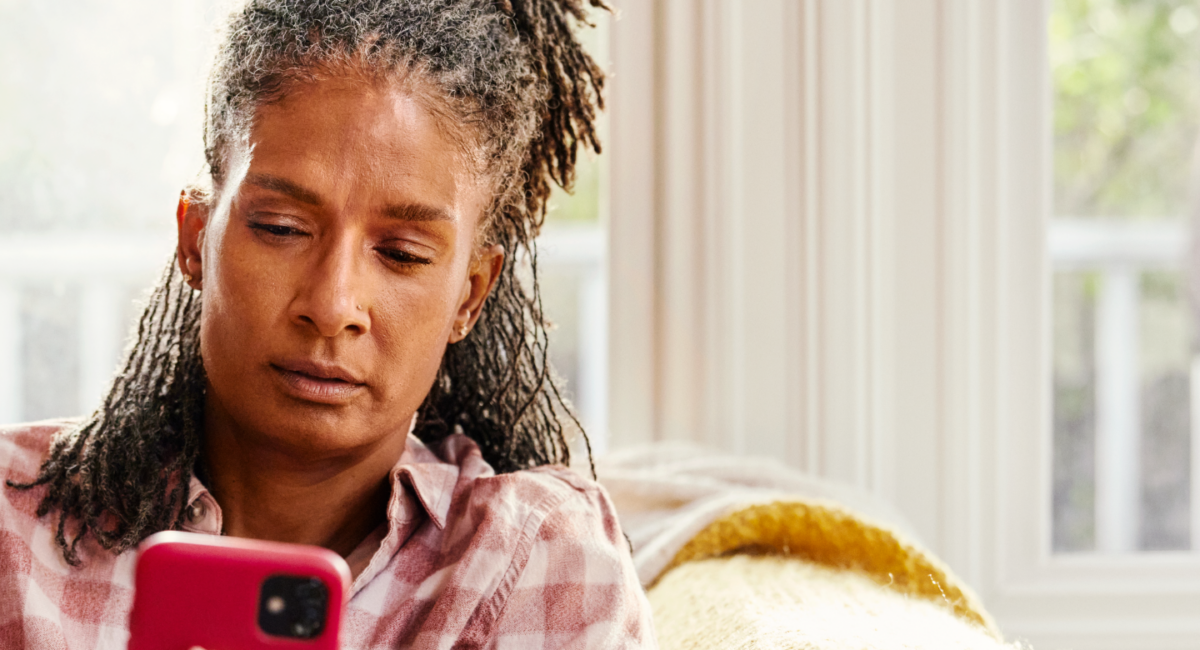 Woman on couch looking at mobile phone