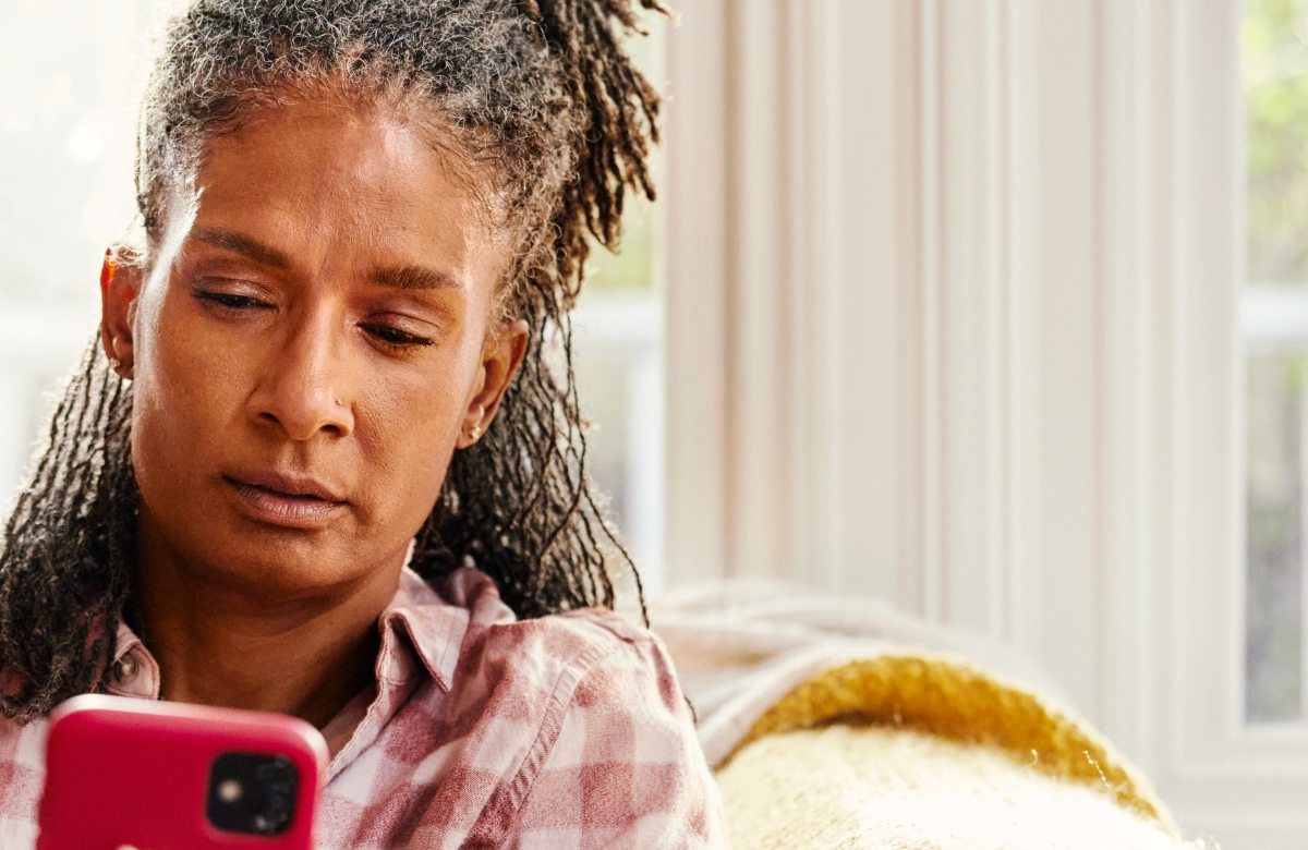 Woman on couch looking at mobile phone