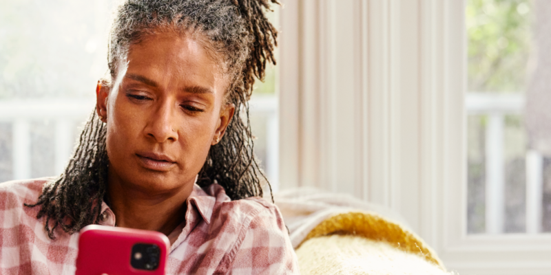 Woman on couch looking at mobile phone