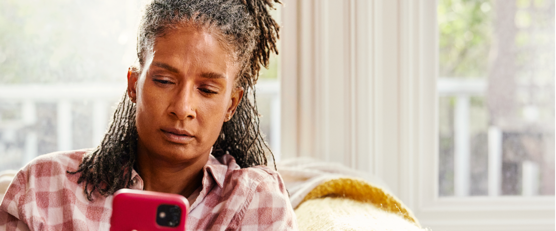 Woman on couch looking at mobile phone