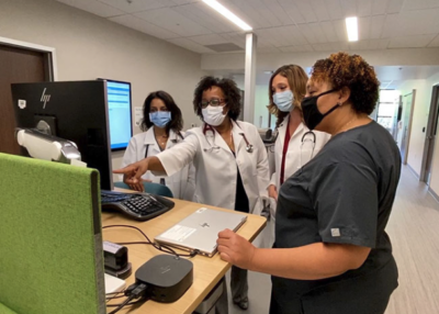Health care workers around a computer